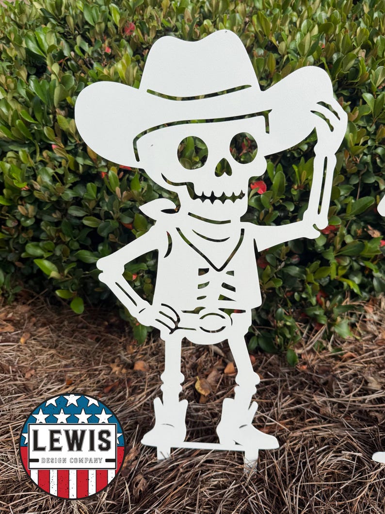 May include: White metal garden art of a skeleton cowboy wearing a hat and boots. The skeleton is holding up the brim of its hat. The design includes a vest, a neckerchief, and a belt buckle. The Lewis Design Company logo is in the lower left corner.