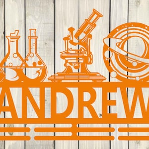 May include: Orange metal wall decor with the name "ANDREW" in large letters. The decor features a microscope, three beakers, and a planet with rings.