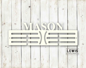 May include: White wooden medal display with the name "MASON" at the top and a baseball graphic in the center. The display has 10 slots for medals.