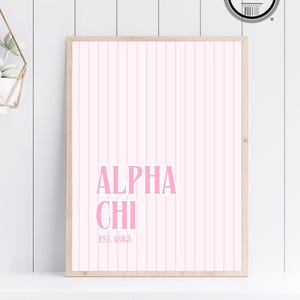 Può includere: Una stampa incorniciata con uno sfondo a righe rosa e bianche. Il testo "ALPHA CHI EST. 1885" è stampato in rosa.