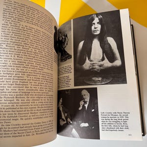 May include: Open book with black and white photographs and text. One photo shows a woman with long hair, another shows two people in a room. The text discusses historical figures and events.