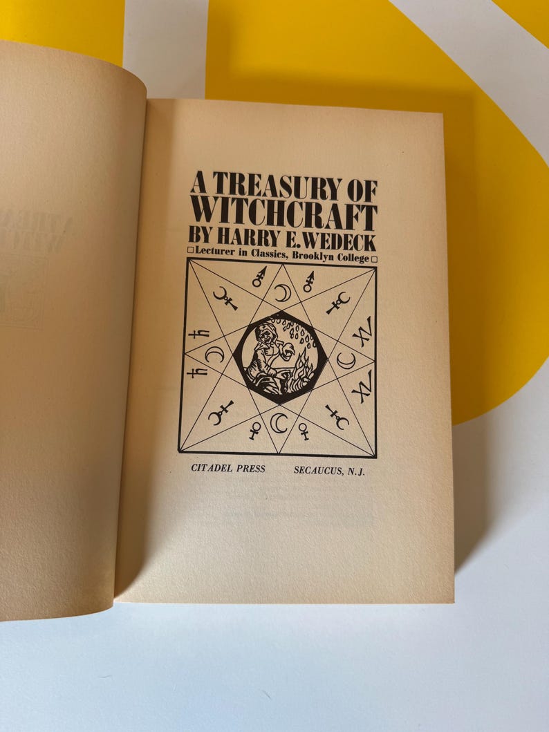 May include: Open book with the title "A Treasury of Witchcraft" by Harry E. Wedeck. The cover features a black and white illustration of a geometric design with symbols and a central figure. Published by Citadel Press.