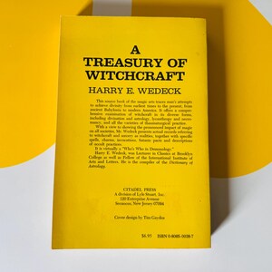 May include: A yellow book titled "A Treasury of Witchcraft" by Harry E. Wedeck. The book's cover features black text and a description of witchcraft's history and practices. The book is from Citadel Press.