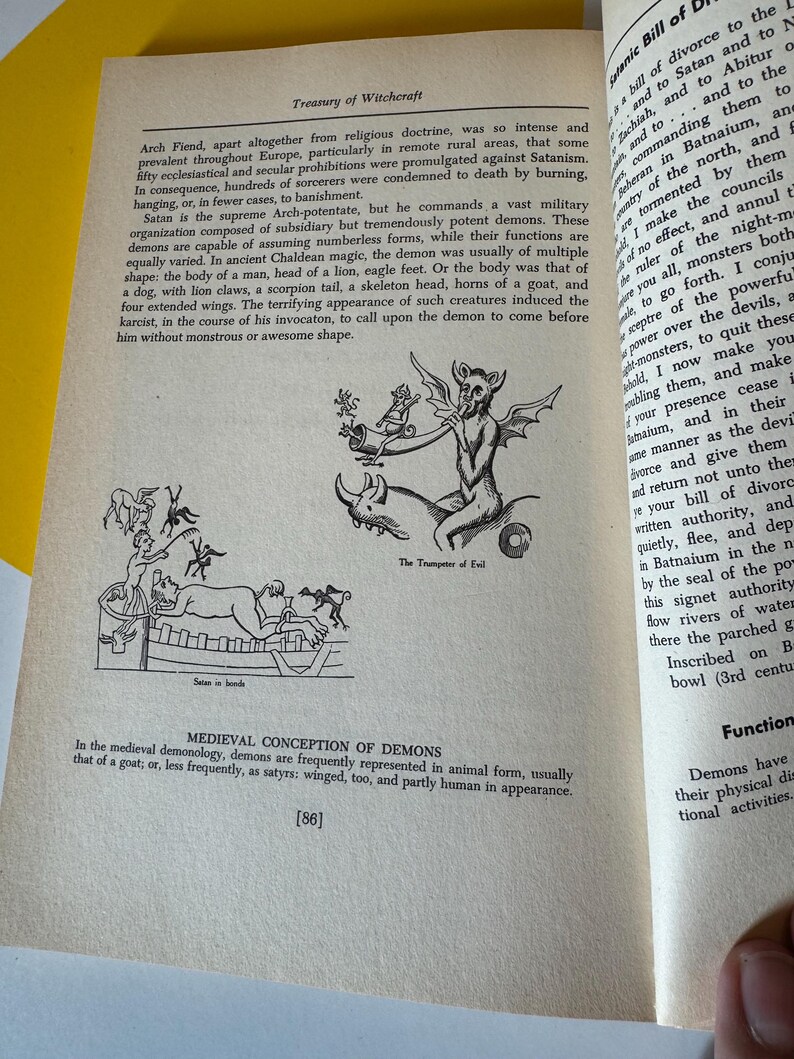 May include: An open book page with text and illustrations about witchcraft. The page features a drawing of a demon playing a trumpet, and another illustration of demons. Text includes "Treasury of Witchcraft" and "Medieval Conception of Demons."