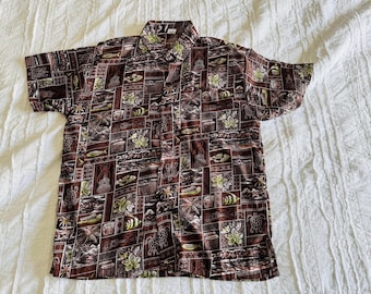 May include: Brown short-sleeve button-down shirt with a repeating pattern of Hawaiian motifs. The design includes images of flowers, turtles, fish, and island scenes in shades of brown, green, and white. The shirt is laid flat on a white surface.