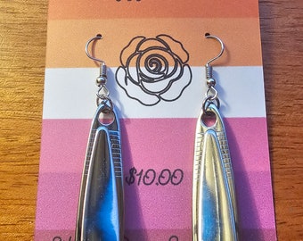 Könnte beinhalten: Ein Paar silberne Nagelschneider-Ohrringe mit einem Rosenmotiv auf der Karte. Die Karte ist rosa, orange und gelb und trägt den Schriftzug "Handmade by Dizzy Marie" und "10,00 €".