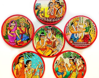 May include: Six round coasters with colorful hand-painted scenes of Hindu deities and mythological figures. The coasters feature intricate details and vibrant colors, including red, yellow, blue, green, and white.