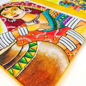 May include: A pair of colorful paintings on canvas depicting a woman and a man in traditional Indian clothing. The woman is wearing a red and yellow sari with a white head covering and a large nose ring. The man is wearing a blue and yellow turban with a red and yellow shirt. Both paintings have a yellow background.