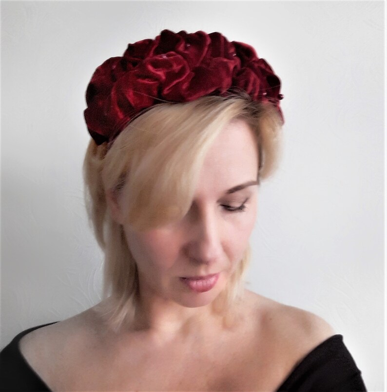 Puede incluir: Una diadema de terciopelo burdeos con un dise&ntilde;o en forma de rosa. La diadema est&aacute; hecha de terciopelo suave y afelpado y est&aacute; adornada con peque&ntilde;as decoraciones brillantes.