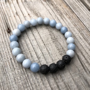 May include: A blue and black beaded bracelet with a gradient of blue beads and black lava rock beads.