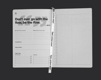 May include: A white notebook with a black and white quote from Jay-Z: "Don't ever go with the flow, be the flow." The notebook has a gray dotted grid pattern and a white ribbon bookmark with the text "Take action now!" repeated three times.
