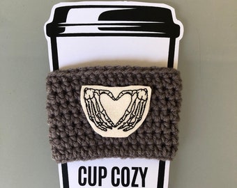 Funda de taza tejida a crochet con forma de calavera y corazón