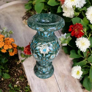 Könnte beinhalten: Eine grüne Marmorvase mit aufwendigen floralen Mustern in Weiß und Blau. Die Vase hat einen runden Körper und einen ausgestellten oberen Teil.
