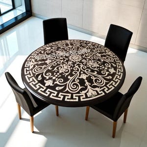 Puede incluir: Una mesa de comedor redonda con una superficie marrón oscuro y complejos diseños florales y geométricos blancos. Cuatro sillas negras con patas de madera rodean la mesa. El diámetro de la mesa es de aproximadamente 122 cm.