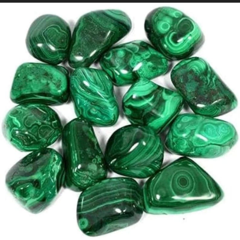 May include: A collection of tumbled malachite stones. The stones are a deep green color with swirling patterns.