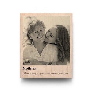 May include: A black and white photo of a mother and daughter hugging and smiling. The photo is printed on a wooden plaque with the word "Mother" and its definition.
