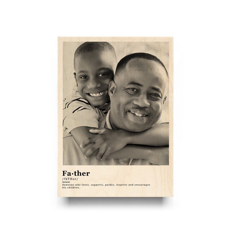 May include: A black and white photo of a father and son hugging. The photo is printed on a wood background with the definition of the word "father" printed below the photo.