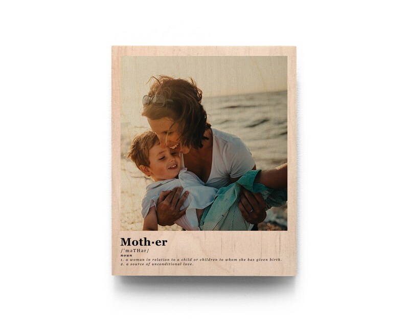 May include: A wood print with a photo of a mother and child hugging on a beach. The print has the word "Mother" with a definition below it.