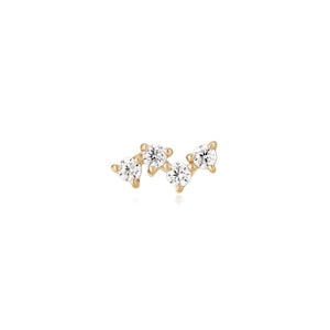 May include: A gold stud earring featuring four round, clear, faceted stones arranged in a staggered, curved cluster. Each stone is held in place by small gold prongs, creating a delicate, multi-stone design that follows a gentle, wave-like arc.