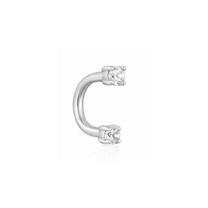 May include: A silver-toned circular barbell body jewelry piece featuring a curved metal shaft with a clear, round faceted gemstone set in a four-prong setting at each end. The metal has a smooth, polished finish and a reflective surface.