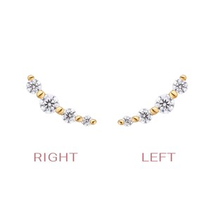May include: A pair of gold ear climbers featuring four round-cut clear stones of varying sizes arranged in a curved line. The left and right earrings are labeled with the text RIGHT and LEFT in a light pink font below each respective piece.