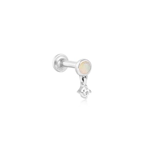 May include: A silver earring featuring a flat back and a small, round opal stone. A small, clear, diamond-shaped stone hangs from the opal. The earring is designed for a single ear piercing.