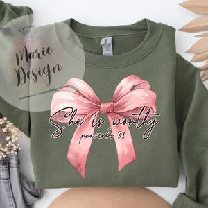 May include: A green sweatshirt with a pink bow and the text "She is worthy Proverbs 31" printed on the front.