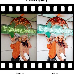 May include: Two people wearing orange and striped shirts stand in front of a green and white sign that reads "HOT  DOUGHNUTS". They are holding a doughnut in front of their faces.
