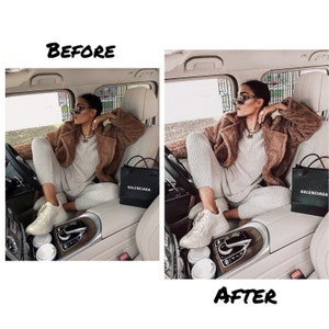 May include: A woman wearing a brown fuzzy jacket, white pants, and white sneakers sits in the passenger seat of a car. She is holding a black shopping bag with the word "BALENCIAGA" printed on it. There are two white coffee cups on the dashboard.