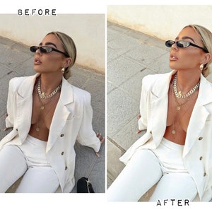 May include: A woman wearing a white blazer, white pants, and gold necklaces. She is wearing black sunglasses and has her hair pulled back.