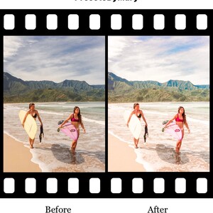 May include: Two women in swimsuits walk along a sandy beach carrying surfboards. The woman on the left is carrying a yellow surfboard and the woman on the right is carrying a pink surfboard. The beach is bordered by lush green mountains and a blue ocean.