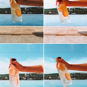 May include: A clear glass bottle with a cork stopper, filled with water and orange slices, held against a backdrop of a blue sky and a pool. The bottle is rectangular and appears to be about 10 inches tall.