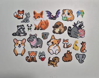 May include: A collection of pixelated animal designs, including foxes, a bat, a guinea pig, a raccoon, a corgi, and a hippo. The animals are rendered in a cross-stitch style with various colors and details.