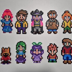 Könnte beinhalten: Eine Sammlung von zehn Pixel-Art-Figuren, jeweils aus bunten Perlen gefertigt. Die Charaktere weisen verschiedene Outfits und Frisuren auf, mit Farben wie Rot, Blau, Grün und Lila. Die Figuren sind in zwei Reihen angeordnet.
