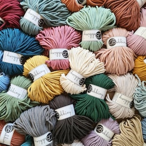 May include: A selection of colourful macrame yarn bundles in shades like teal, pink, yellow, and cream. Each bundle is labelled with "Bobbiny". The yarn is tightly wound, indicating it's suitable for crafting projects. A variety of colours are visible.