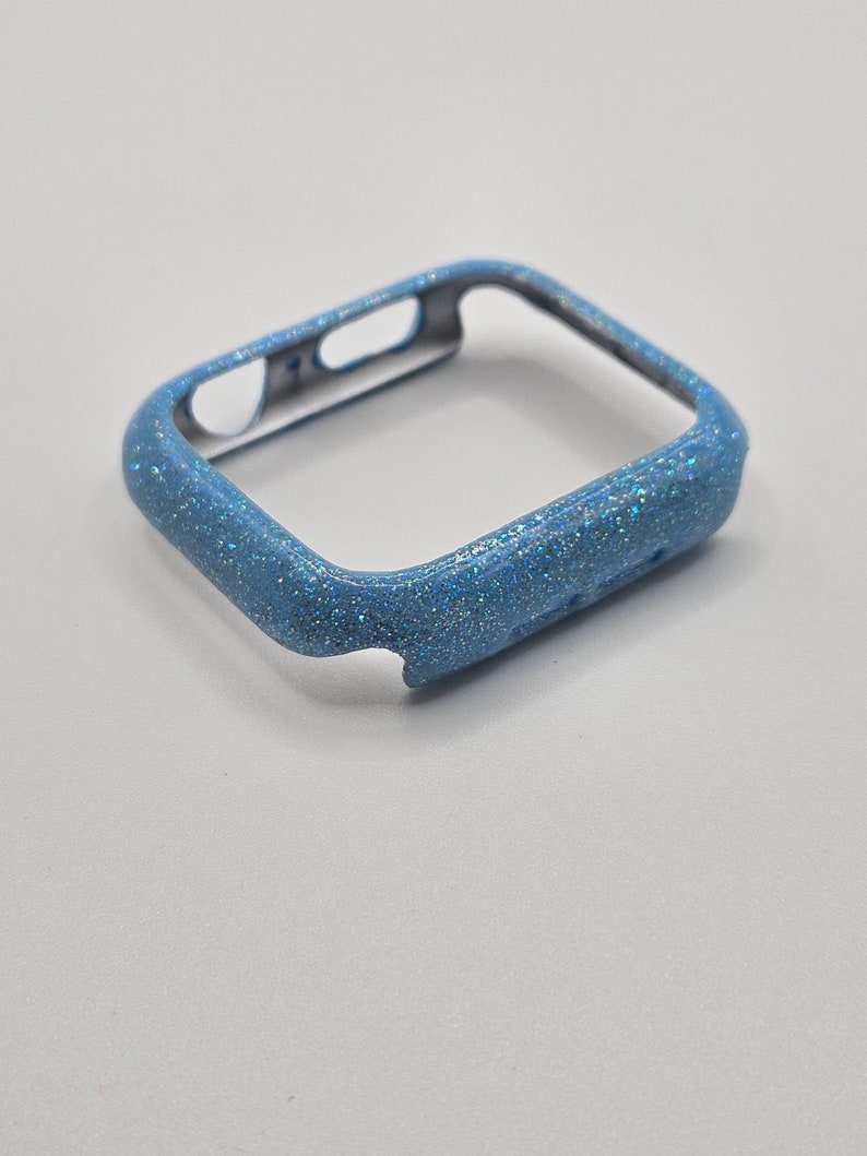 May include: A light blue glitter watch case for an Apple Watch.