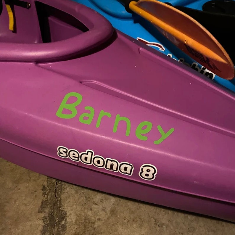 May include: Purple kayak with a green "Barney" sticker and a white "sedona 8" sticker.