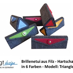 Könnte beinhalten: Sechs Brillenetuis aus Filz in verschiedenen Farben, darunter Rot, Blau, Grün, Gelb und Orange. Die Etuis sind dreieckig und haben eine Klappe, die mit einem Knopf verschlossen wird. Der Text "voigt design" und "HANDMADE IN GERMANY" ist unten im Bild zu sehen.