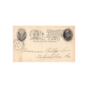 May include: A vintage postcard with a black and white image of a man's face in the upper right corner. The postcard has a stamp with a black and white image of an eagle and the text "United States Post Office" and "One Cent." The postcard also has a stamp with the text "Philadelphia, Pa." and "Jun 3 1914." The postcard has the text "POSTAL CARD." and "THE SPACE BELOW IS FOR THE ADDRESS ONLY." The postcard has handwritten text that reads "American Pulley Co. Philadelphia, Pa."