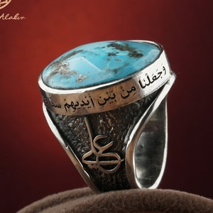 May include: A silver ring with a turquoise stone and Arabic script. The script reads "وَحَقَّنَا مِنْ بَنِي إِسْرَائِيلَ سِتَّةَ مِنْهُمْ" and "عَلِيّ".