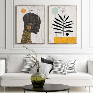 May include: Two abstract art prints with a white background. The print on the left features a black silhouette of a person's head with a yellow and orange patterned design. The print on the right features a black silhouette of a plant with a yellow and orange patterned design at the bottom.