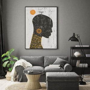 May include: A black and white illustration of a person's head with a yellow sun and black and white floral patterns. The illustration is framed and hanging on a gray wall above a gray couch.