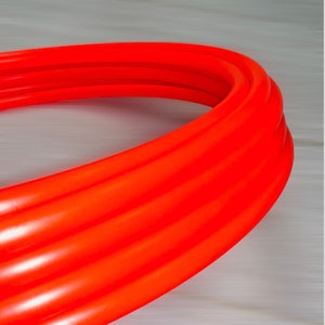 May include: A bright orange, flexible, corrugated pipe.