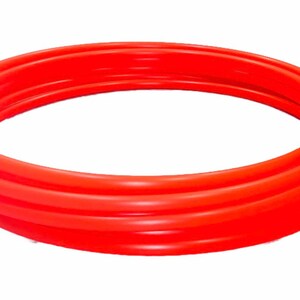 May include: A bright red inflatable ring, made of thick plastic, is folded in on itself. The ring is circular and appears to be a pool float.