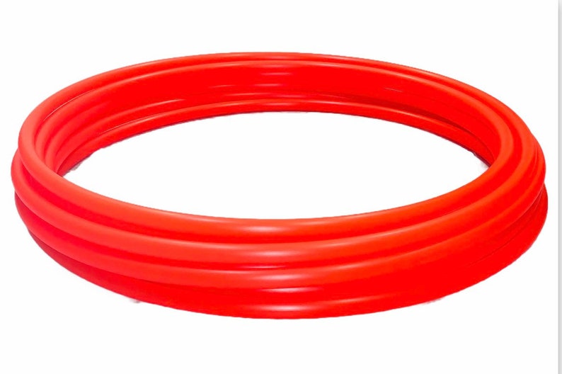 May include: A bright red inflatable ring, made of thick plastic, is folded in on itself. The ring is circular and appears to be a pool float.