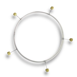 Puede incluir: Un aro plateado con cinco borlas de color dorado sujetas a &eacute;l.