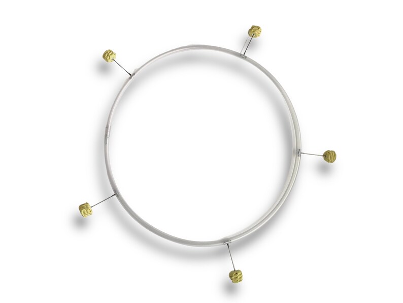 Puede incluir: Un aro plateado con cinco borlas de color dorado sujetas a &eacute;l.