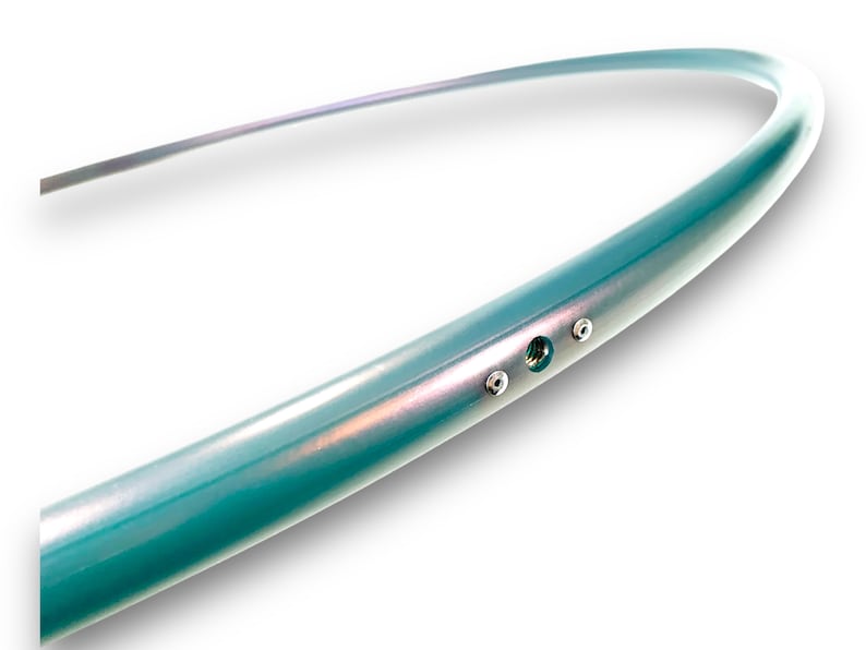 Puede incluir: Primer plano de un aro de color turquesa con tres tornillos plateados. El aro est&aacute; hecho de un material liso y brillante.