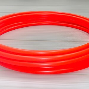 May include: A bright orange inflatable pool ring, made of thick plastic, is ready for summer fun.