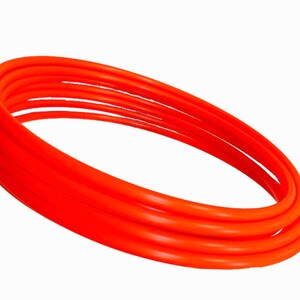 May include: A set of four orange plastic hula hoops stacked on top of each other.